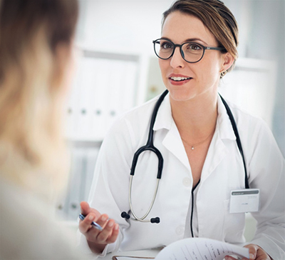 Женщина-врач разговаривает с пациентом